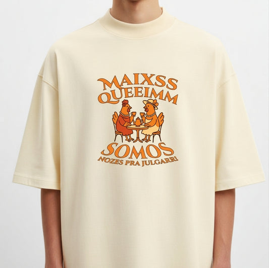 Camiseta com estampa frontal de duas galinhas sentadas à mesa com copos, cercadas por texto estilizado em torno delas.