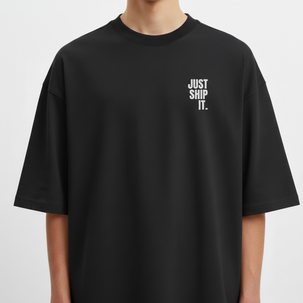 Camiseta com estampa frontal de texto "JUST SHIP IT." em letras maiúsculas e estampa traseira de mesma frase com detalhes em fundo irregular.