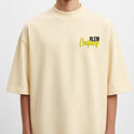 Camiseta com estampa frontal de texto estilizado com as palavras "RLEM Company" e estampa traseira de lâmpada vintage acompanhada da frase "SEJA LUZ EM MEIO AO CAOS".