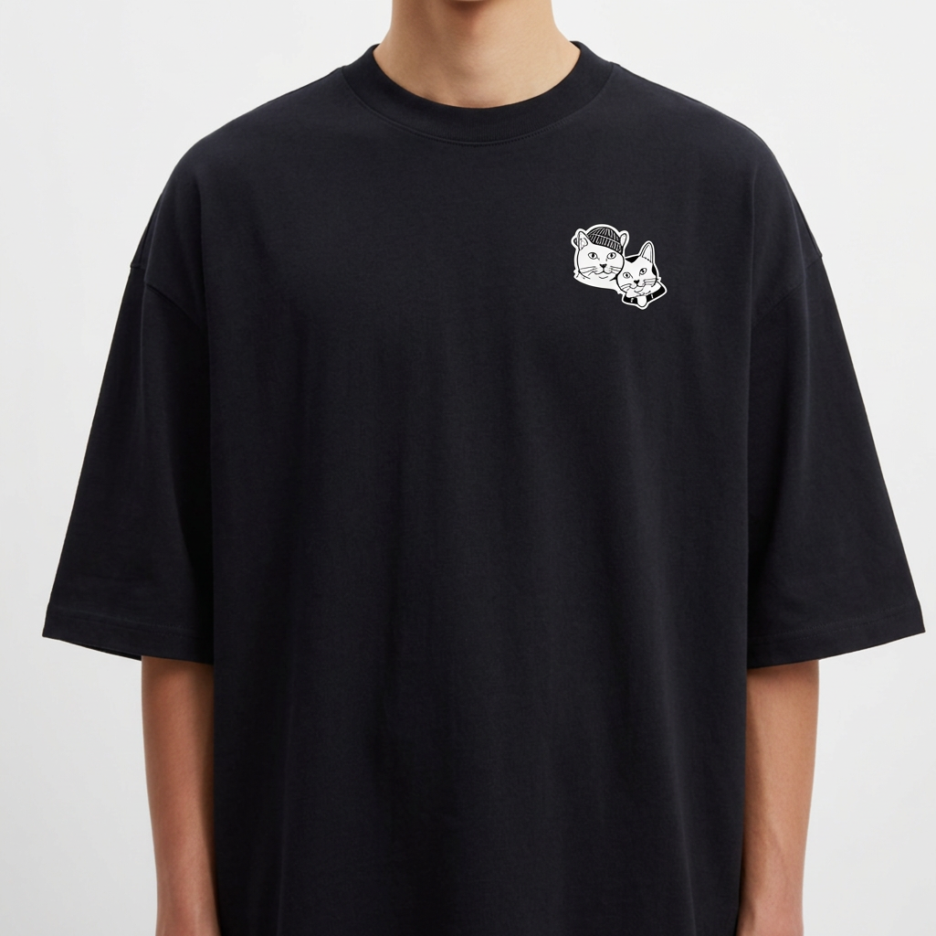 Camiseta com estampa frontal de duas cabeças de gatos em estilo ilustrativo e estampa traseira de dois gatos sentados rodeados por detalhes artísticos.