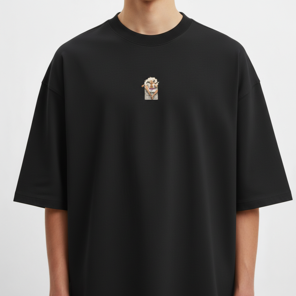 Camiseta com estampa frontal de pequeno personagem segurando cartaz e estampa traseira de personagem em pose dinâmica com fundo de fumaça e texto estilizado acima.