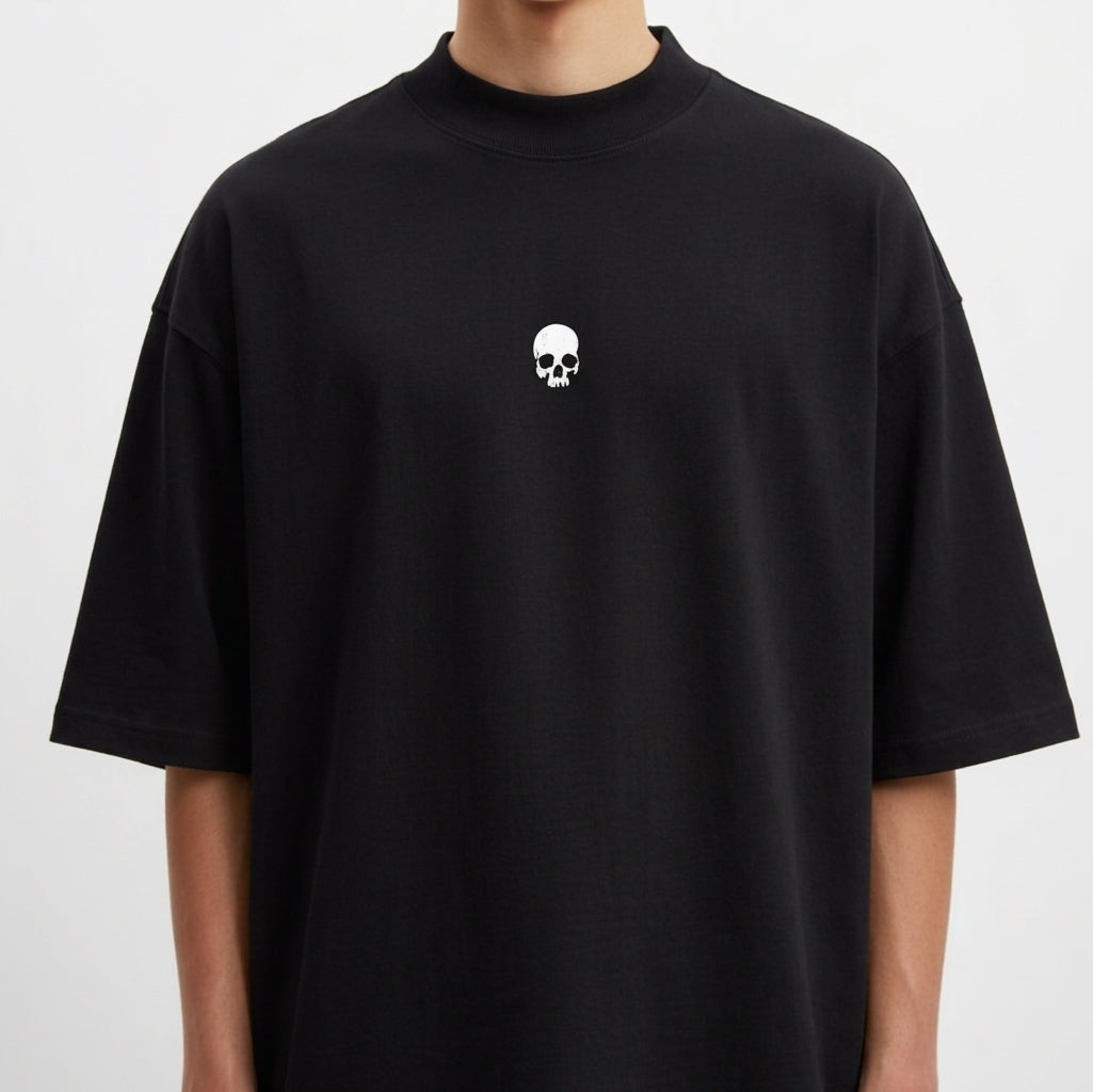 Camiseta com estampa frontal de caveira pequena e estampa traseira de pássaro em voo com texto estilizado por baixo, criando um contraste marcante.