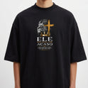 Camiseta com estampa frontal de leão em perfil ao lado de uma cruz, seguida pela frase "Ele não reina por acaso" e texto menor detalhando uma passagem.