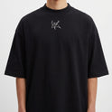 Camiseta com estampa frontal de linha abstrata com figura estilizada e estampa traseira de dado vermelho rodeado por fumaça em tons ondulantes.