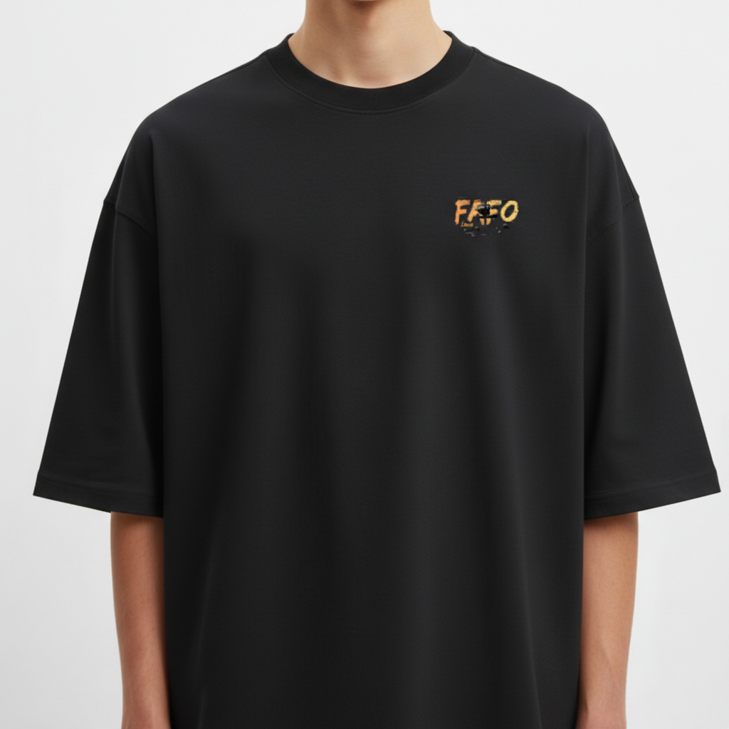 Camiseta com estampa frontal de "FAFO" em destaque e estampa traseira com figura masculina, helicópteros ao fundo e a frase "Fuck Around Find Out".