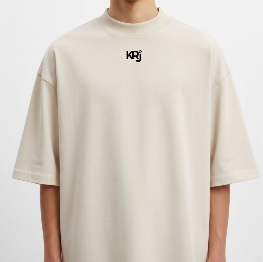 Camiseta com estampa frontal de "KRJ" estilizado e estampa traseira de mão segurando relógio de bolso com corrente detalhada.