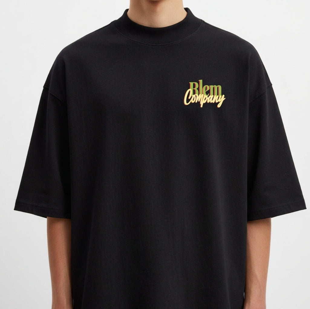 Camiseta com estampa frontal de "Blem Company" estilizado em tipografia mista e estampa traseira de uma cabeça clássica com rodelas de pepino nos olhos.