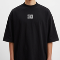 Camiseta com estampa frontal de "STACK" em letras grandes e estampa traseira de "BACKEND MACHINE behind the scenes" sobreposta em fundo com "STACK".