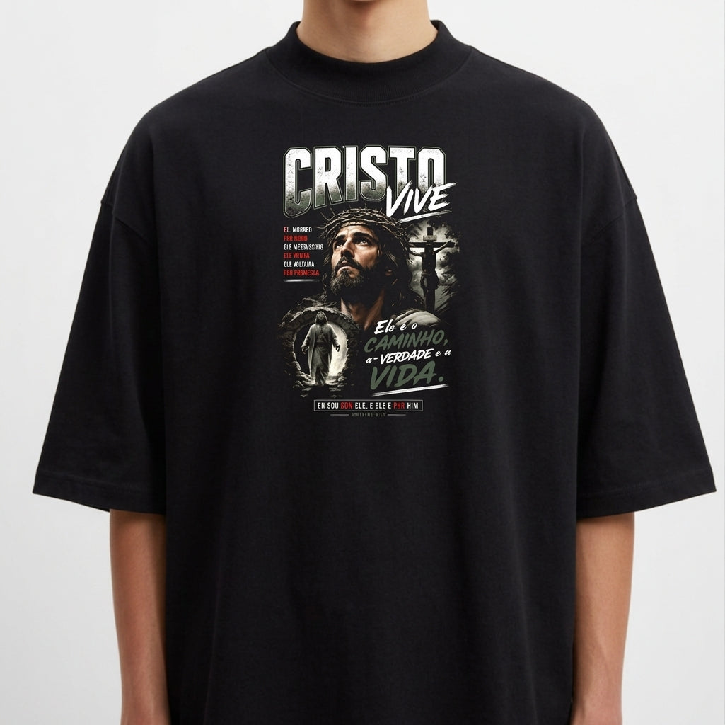 Camiseta com estampa frontal de um rosto cercado por elementos religiosos, incluindo uma cruz, e frases destacando mensagens espirituais.
