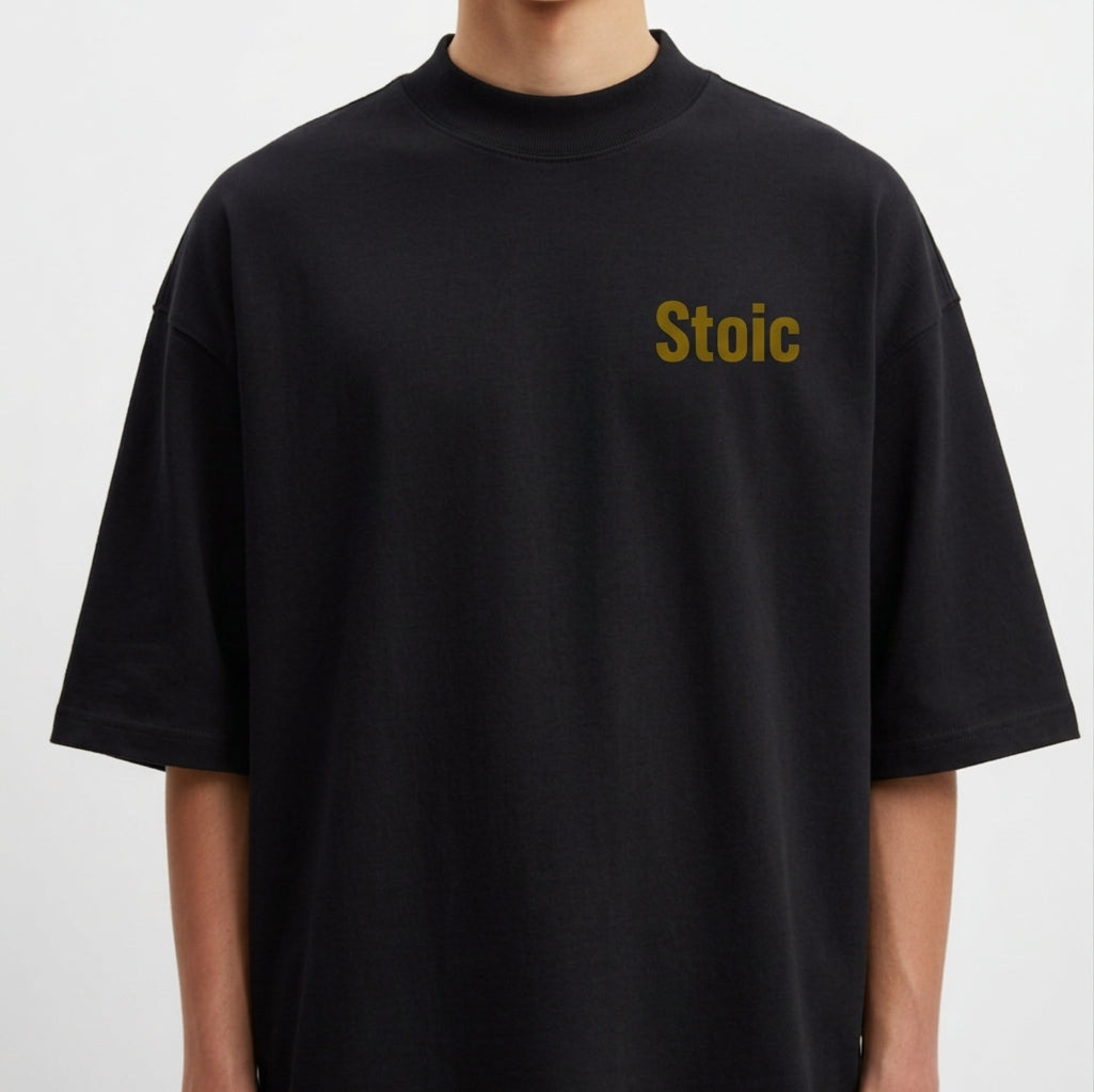 Camiseta com estampa frontal de "Stoic" no peito e estampa traseira com o texto "Love of One's Fate", acompanhada de parágrafo reflexivo e símbolos.