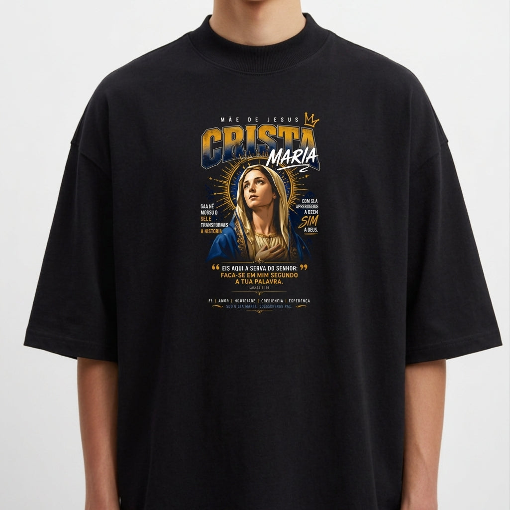 Camiseta com estampa frontal da imagem de Maria com coroa e auréola, cercada por texto estilizado, destacando frases e pequenas ilustrações gráficas.