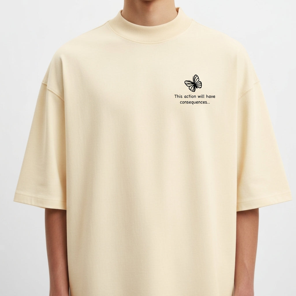 Camiseta com estampa frontal de borboleta pequena acompanhada da frase “This action will have consequences...” e estampa traseira de arte com personagem estilizada segurando uma arma, cercada por palavras e símbolos, incluindo "STRANGE" em destaque.