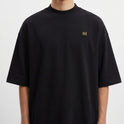 Camiseta com estampa frontal do monograma "H" minimalista e estampa traseira de imagem artística com mãos semelhantes a "A Criação" e texto "Born from Caffeine".