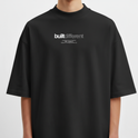Camiseta com estampa frontal de texto "built different" em destaque, acompanhado por linhas menores com frases adicionais, em um estilo moderno e impactante.