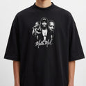 Camiseta com estampa frontal de três figuras masculinas em estilo retrato, acompanhada de uma assinatura cursiva abaixo delas.