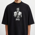 Camiseta com estampa frontal de uma figura masculina segurando um microfone, envolta de efeitos gráficos, com o nome "Nelly" em letras cursivas abaixo.
