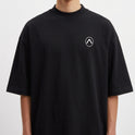 Camiseta com estampa frontal de símbolo geométrico simples no peito e estampa traseira de skatista em ação com efeito gráfico de tinta em respingos.