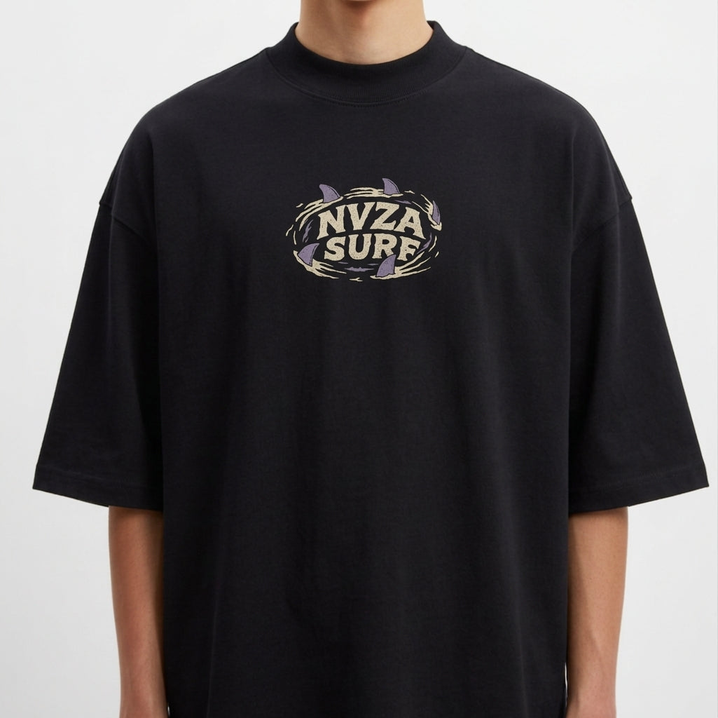 Camiseta com estampa frontal de texto centralizado "NVZA SURF" rodeado por um desenho de tubarões que criam forma circular em torno das letras.