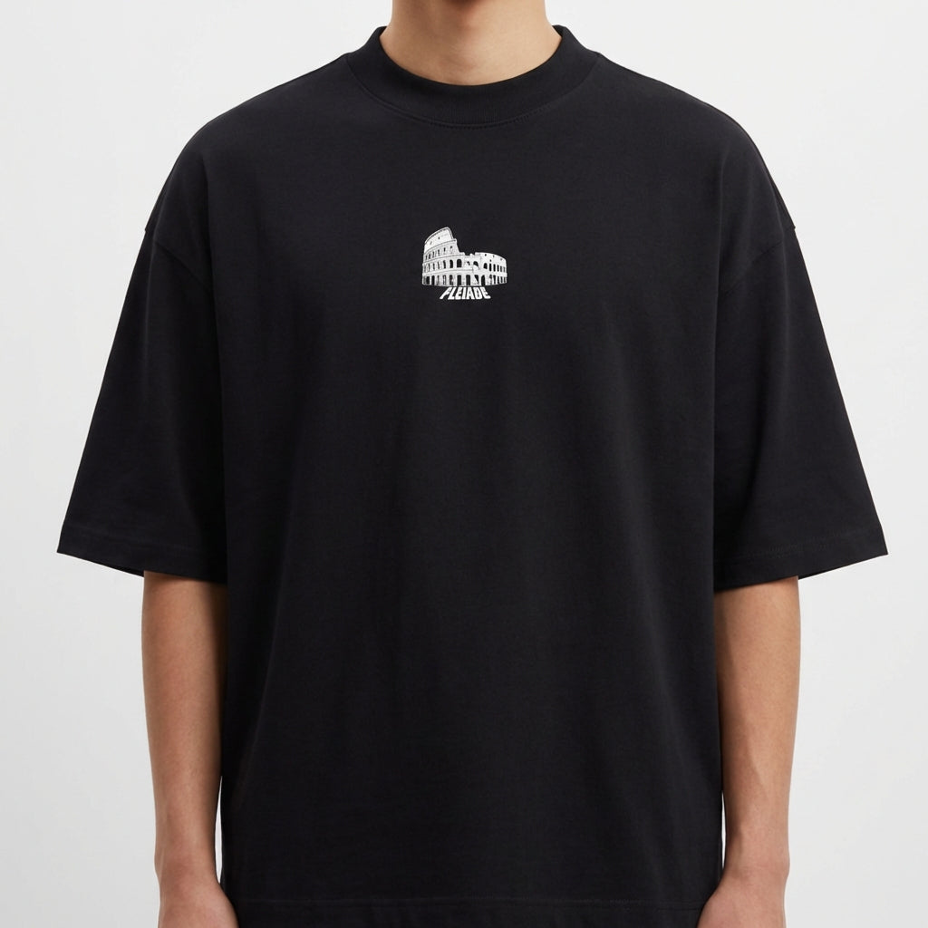 Camiseta com estampa frontal de uma estrutura arqueológica e estampa traseira de figura religiosa carregando uma cruz com a palavra "JESUS" em destaque.
