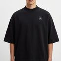 Camiseta com estampa frontal de símbolo minimalista no canto inferior e estampa traseira de paisagem praiana ao entardecer com padrão de calçada ondulada.
