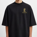 Camiseta com estampa frontal de um emblema dourado com uma coroa, texto "O Rei Macaco (Sun Wukong)" e estampa traseira de uma ilustração detalhada com "Lenda 3: O Rei Macaco".