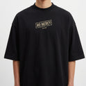 Camiseta com estampa frontal de logotipo retangular "NO MERCY CLUB" e estampa traseira de cobra enrugada com texto "STRIKE HARD NO MERCY" e caracteres orientais.