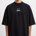 Camiseta com estampa frontal de duas caveiras cruzadas acima da palavra "LOWKEY" e estampa traseira da mesma palavra em estilo sombreado.