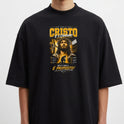 Camiseta com estampa frontal de uma figura religiosa cercada por textos e elementos gráficos detalhados, incluindo frases em destaque e simbologia variada.