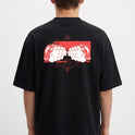 Camiseta com estampa frontal de texto "COMPANY" em relevo e estampa traseira de ilustração artística com rostos repetidos sobre fundo geométrico.