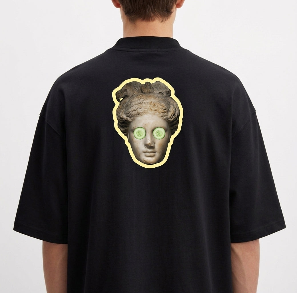 Camiseta com estampa frontal de "Blem Company" estilizado em tipografia mista e estampa traseira de uma cabeça clássica com rodelas de pepino nos olhos.