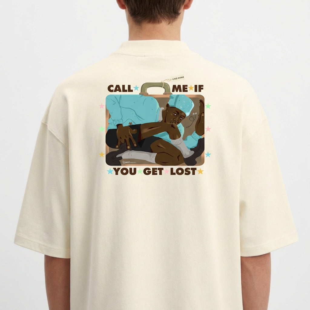 Camiseta com estampa frontal de texto "CALL ME IF YOU GET LOST" adornado com pequenas estrelas coloridas e estampa traseira de ilustração com figura relaxando em mala.
