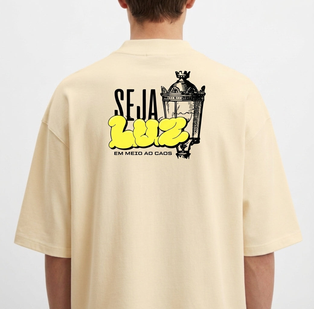 Camiseta com estampa frontal de texto estilizado com as palavras "RLEM Company" e estampa traseira de lâmpada vintage acompanhada da frase "SEJA LUZ EM MEIO AO CAOS".