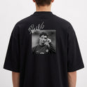 Camiseta com estampa traseira de fotografia em preto e branco de um jogador de futebol em campo, sobreposta por assinatura estilizada brilhante.
