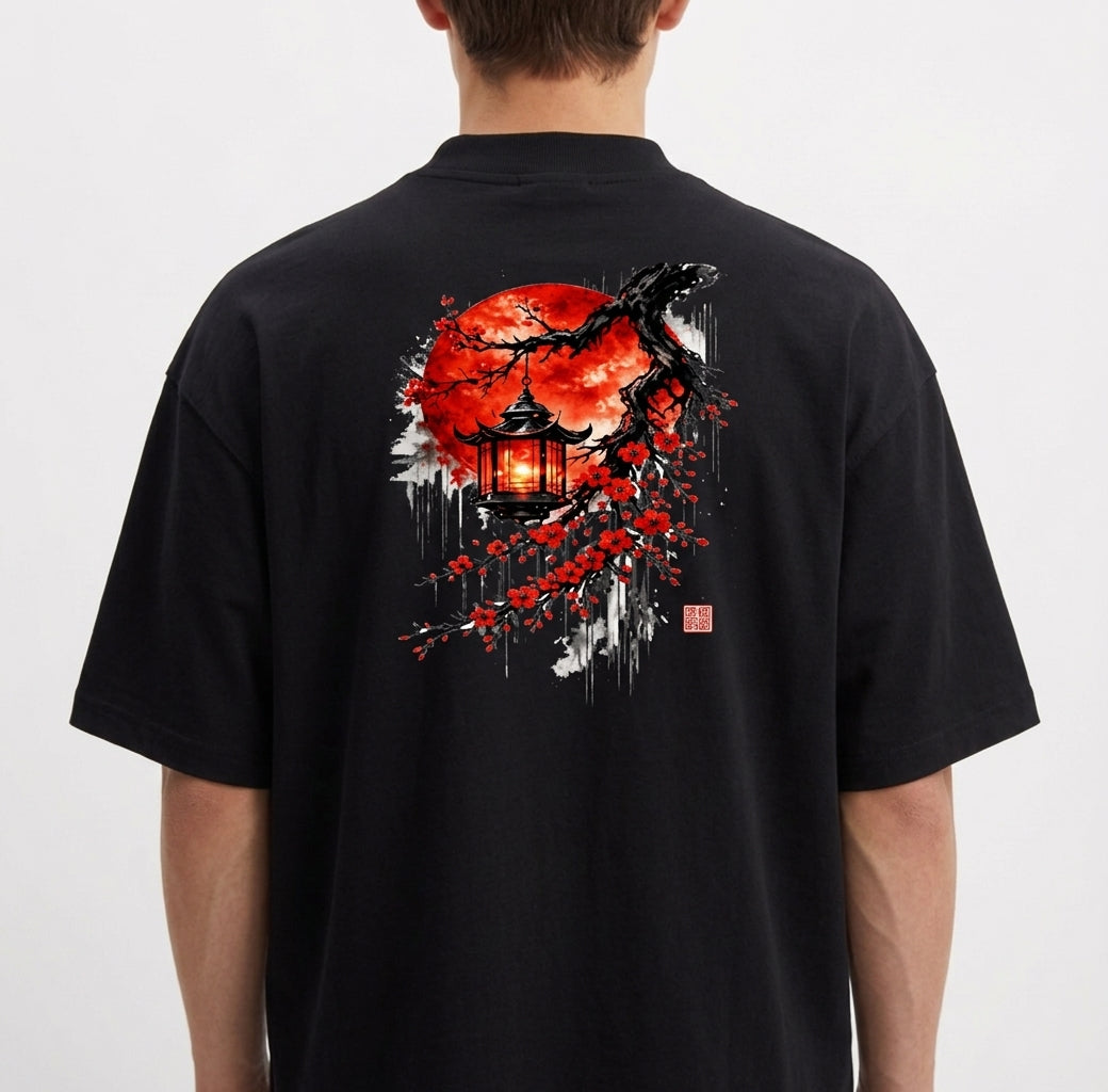 Camiseta com estampa frontal de texto "LUNOVA" com símbolo acima e estampa traseira de lanterna japonesa sob árvore de cerejeira com lua vermelha ao fundo.