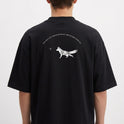 Camiseta com estampa frontal de uma raposa em um círculo sob uma estrela e estampa traseira de raposa caminhando com texto curvo acima e pequena estrela à frente.