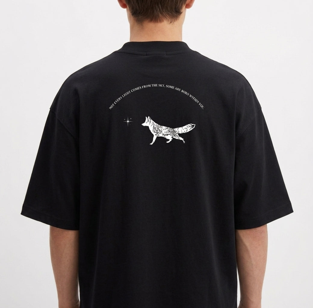 Camiseta com estampa frontal de uma raposa em um círculo sob uma estrela e estampa traseira de raposa caminhando com texto curvo acima e pequena estrela à frente.