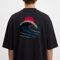 Camiseta com estampa frontal de pequeno emblema circular contendo uma seta direcionada para cima e estampa traseira de grande onda em estilo retrô com sol vermelho.