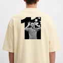 Camiseta com estampa traseira de uma figura dentro do número onze, acompanhada de um fundo repleto de estrelas em um formato dinâmico.