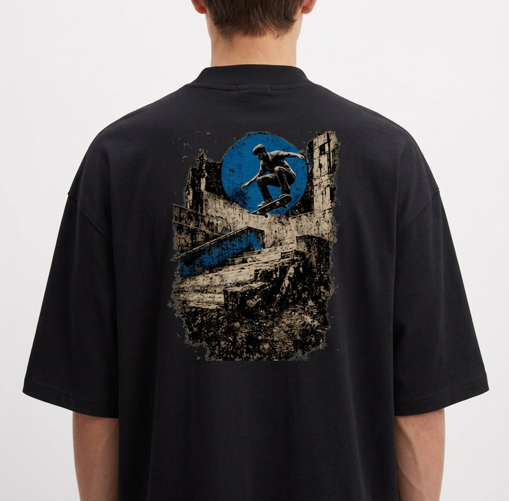 Camiseta com estampa frontal de logo minimalista circular e estampa traseira de skatista sobre ruínas urbanas e círculo abstrato.