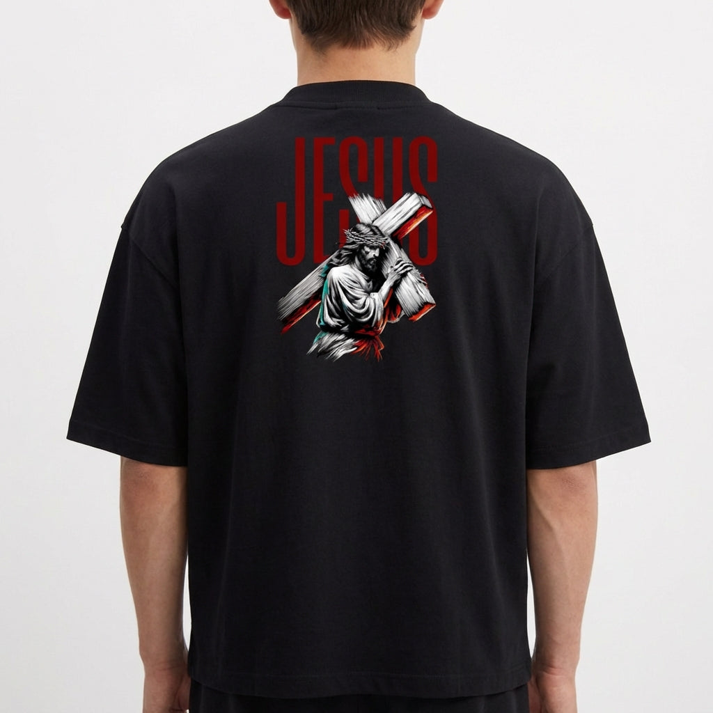 Camiseta com estampa frontal de uma estrutura arqueológica e estampa traseira de figura religiosa carregando uma cruz com a palavra "JESUS" em destaque.