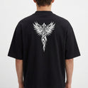 Camiseta com estampa traseira de uma cruz estilizada com asas detalhadas, onde os traços lembram penas e se entrelaçam, formando uma figura imponente.