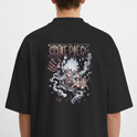Camiseta com estampa frontal de pequeno personagem segurando cartaz e estampa traseira de personagem em pose dinâmica com fundo de fumaça e texto estilizado acima.