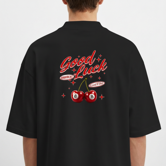 Camiseta com estampa traseira de cerejas tipo bola 8, cercadas por estrelas, acompanhadas das frases "Good Luck", "Good Vibes" e "Rawbeat".