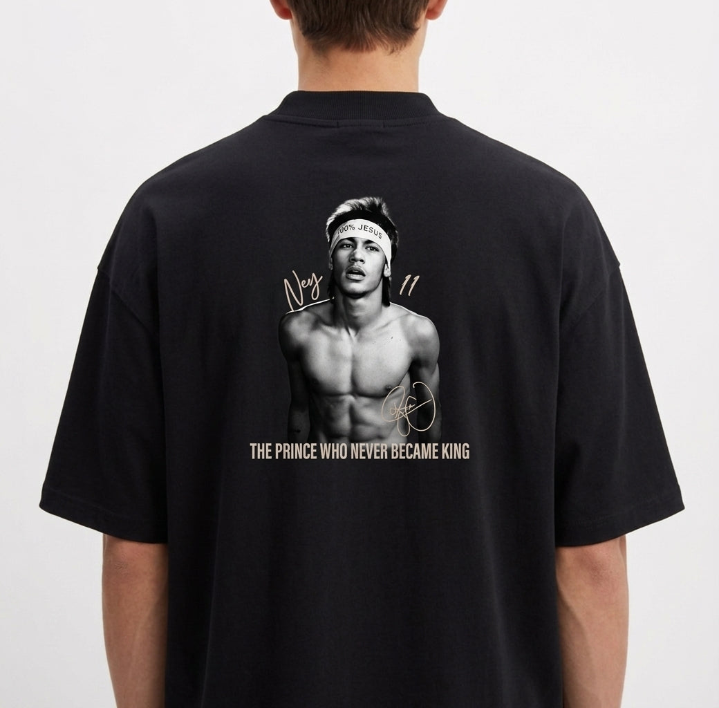 Camiseta com estampa frontal de assinatura estilizada e estampa traseira de retrato de homem sem camisa, assinaturas e frase "The Prince Who Never Became King".
