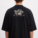 Camiseta com estampa frontal de texto estilizado distorcido e estampa traseira de ilustração angelical com espadas cruzadas e letras decorativas.