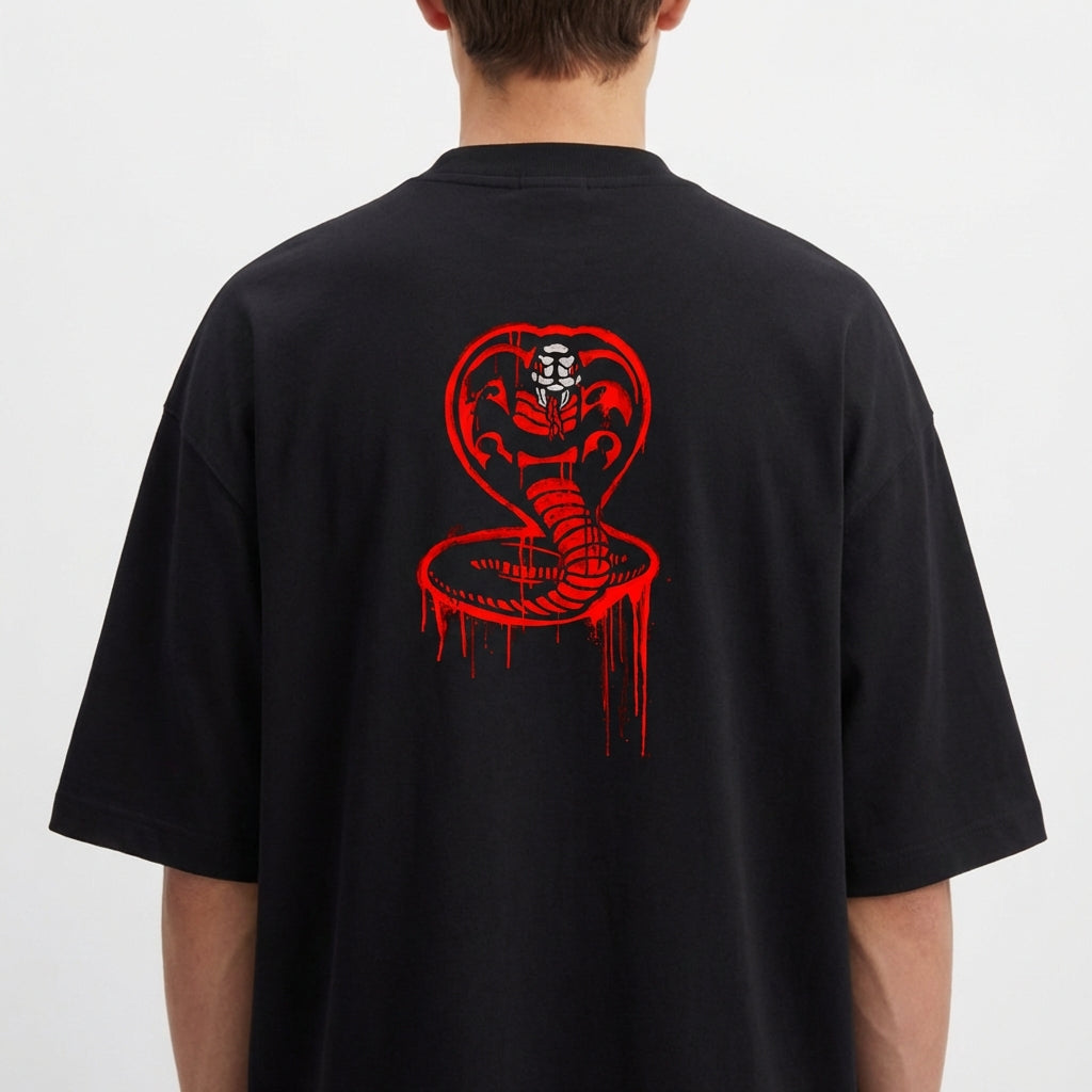 Camiseta com estampa frontal de "No Mercy Club" em estilo gotejante e estampa traseira de cobra desenhada com detalhes ousados em estilo gráfico.