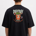 Camiseta com estampa frontal de texto estilizado "DESTROY" e estampa traseira de copo antropomórfico com verduras, textos e bebida ao lado.