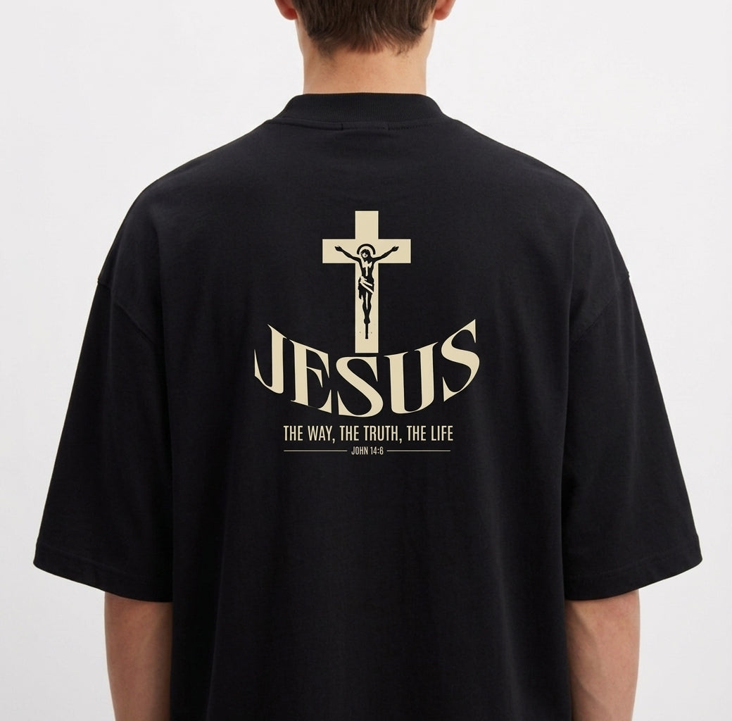 Camiseta com estampa frontal de lettering "God is Good" em estilo grafite e estampa traseira de crucifixo sobre a palavra "Jesus" e texto relacionado.