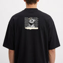 Camiseta com estampa frontal de uma escultura clássica com texto estilizado repetido e detalhe de rasgo, e estampa traseira similar ampliada e centralizada.