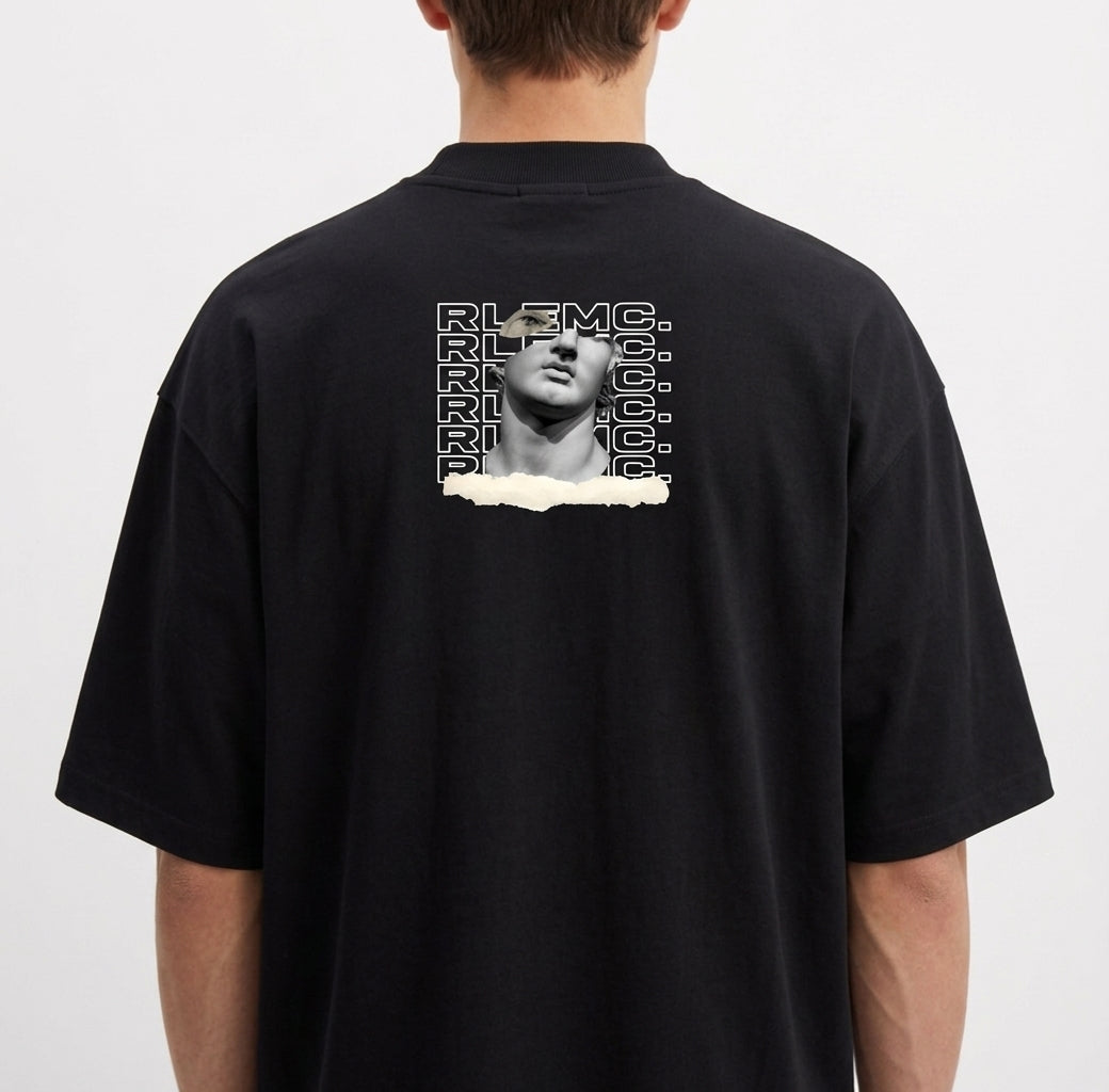 Camiseta com estampa frontal de uma escultura clássica com texto estilizado repetido e detalhe de rasgo, e estampa traseira similar ampliada e centralizada.